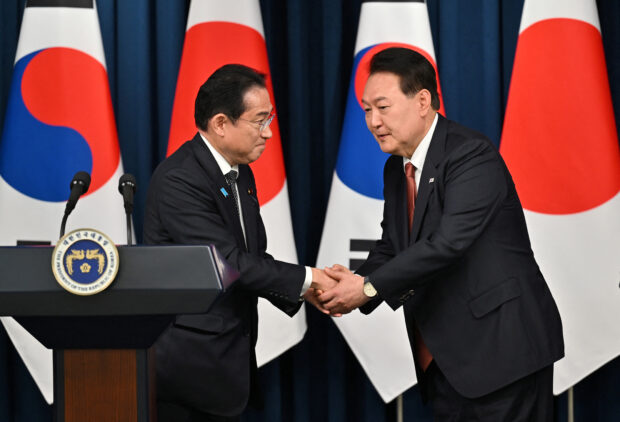FILE PHOTO: South Korean President Yoon Suk Yeol shakes hands with Japanese Prime Minister Fumio Kishida during a joint press conference after their meeting at the presidential office in Seoul on May 7, 2023. Jung Yeon-je/Pool via REUTERS