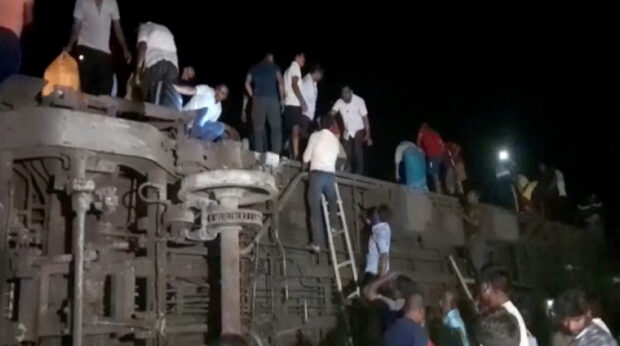 People try to escape from toppled compartments, following the deadly collision of two trains, in Balasore, India June 2, 2023, in this screen grab obtained from a video. ANI/Reuters TV via REUTERS