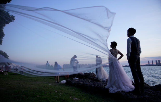 Zhang Zijian and Kang Yifei pose for photographs during a wedding photo shoot at a park following the coronavirus disease (COVID-19) outbreak, in Suzhou, Jiangsu province, China Aug. 13, 2020. STORY: Marriages in China slump to historic low