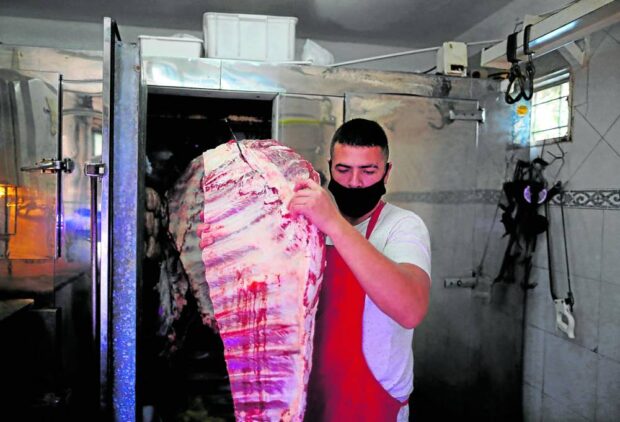A butcher carries a “costillar” (cow ribs) out of the fridge at his shop in General Pacheco on the outskirts of Buenos Aires, Argentina, in a photo taken on May 19, 2021. STORY: Argentines grilling more steaks despite 109% inflation