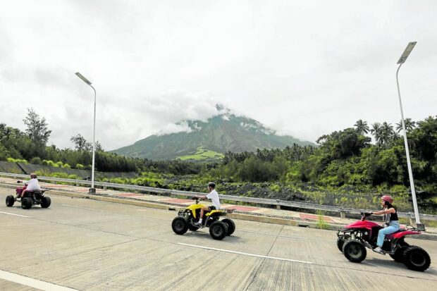 The Philippine Institute of Volcanology and Seismology places Mayon Volcano under alert level 2 after its monitoring of the summit crater shows an increased rockfall. On Monday, several tourists are seen still enjoying all-terrain vehicle rides in Daraga, Albay, as clouds obscure the view of Mayon. STORY: ‘Increasing unrest’ in Mayon, Taal; residents relocated
