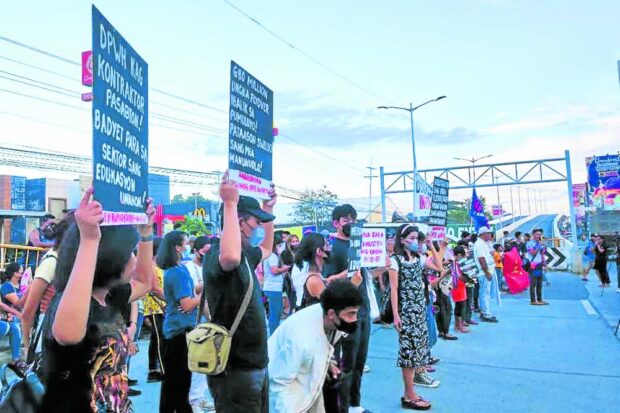 Protesters gather at the foot of the closed Ungka flyover in Pavia, Iloilo, on May 23, 2023, to demand accountability in the spending of public infrastructure funds. STORY: DPWH execs, contractor sued over ‘sinking’ flyover