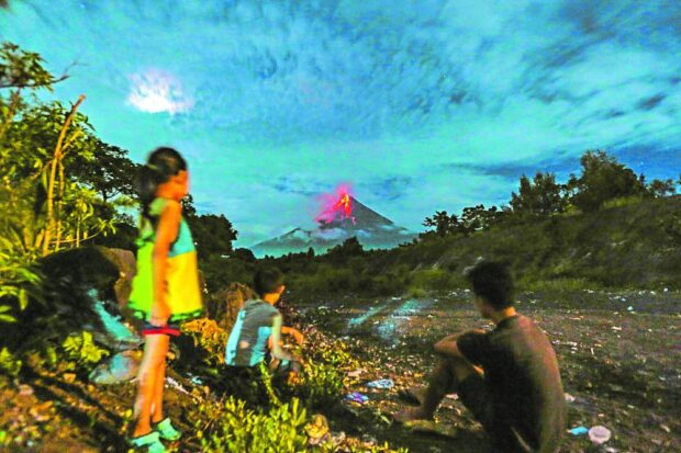 Children watch in amazement the lava flow and listen to the rumbling of rockfall at night that can be seen and heard from areas within the extended 7-kilometer permanent danger zone of the restive Mayon Volcano. This photo was taken in Barangay Matanag, Legazpi City, Albay, on June 22, 2023. STORY: Restive Mayon still attracting more tourists to Albay