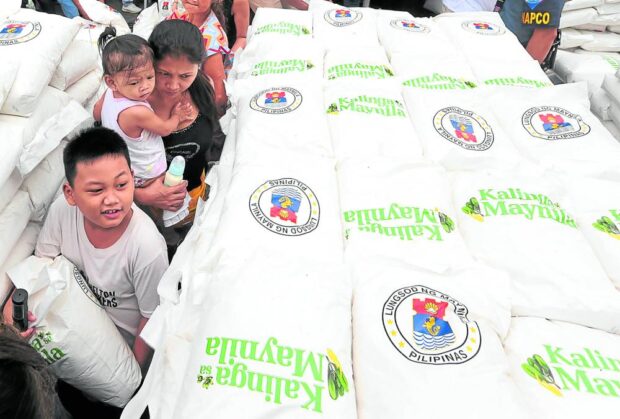 FOOD AID Residents of Sampaloc district in Manila receive 10 kilos of rice on Friday during the “Kalinga ng Maynila,” a local government program providing medical, legal and other assistance to residents. The food aid comes as some lawmakers and workers’ groups say the P40 wage increase in Metro Manila is not enough for their daily needs. —MARIANNE BERMUDEZ Wage hike kilo rice