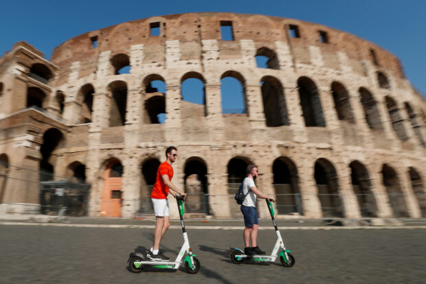 FILE PHOTO: E-scooters gone wild! People ride electric scooters past the Colosseum in Rome