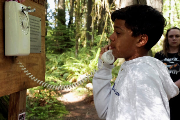 Grieving relatives talk to lost loved ones on phone in the forest
