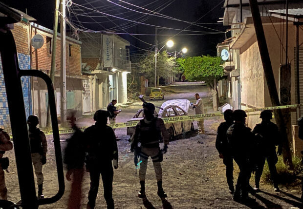 Federal forces keep watch at the scene of an overnight car blast in Celaya
