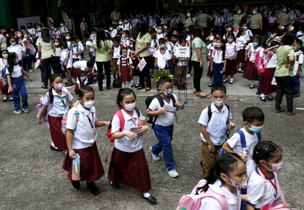 In this photo taken in August 2022, teachers at Aurora Quezon Elementary School in San Andres, Manila, guide their students on the first day of school following the resumption of in-person classes after two years of distance learning due to the pandemic. STORY: Shift to old school calendar gets teachers’ support