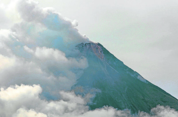 DECEPTIVE CALMNESS The summit of Mt. Mayon in Albay province, which is partly covered with clouds in this photo taken on June 5, appears calm but it has been under alert level 2 after exhibiting signs of unrest since Sunday. —MARK ALVIC ESPLANA