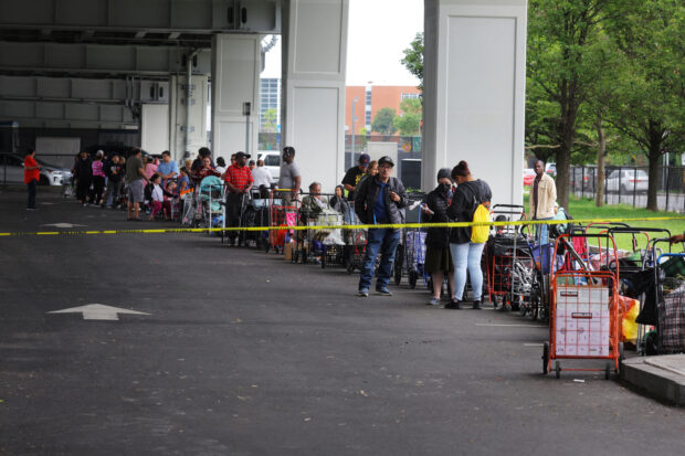FILE PHOTO: Residents wait in line at the food pantry run by La Colaborativa in Chelsea