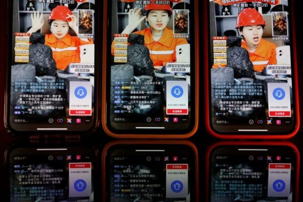 A livestreamer promotes coal during a livestreaming session for Huaze Coal Industry on the Douyin app, in this illustration picture taken June 15, 2023. REUTERS/Florence Lo/Illustration