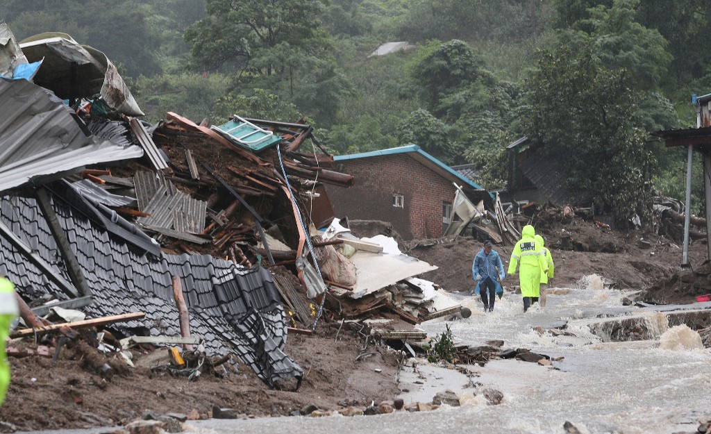 South Korean emergency workers search for survivors after a landslide hit a small village in Yecheon on July 15, 2023. Seven people have been killed and three were missing as heavy rains flooded South Korea, officials said on July 15, with thousands told to evacuate their homes due to an overflowing dam. (Photo by YONHAP / AFP) / - South Korea OUT / REPUBLIC OF KOREA OUT  NO ARCHIVES  RESTRICTED TO SUBSCRIPTION USE