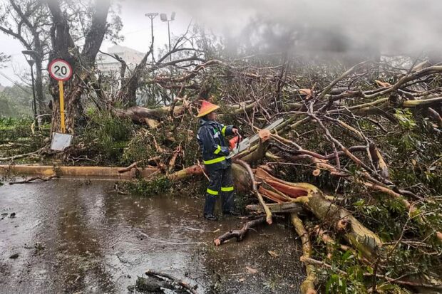 This handout photograph taken and released by the Baguio City Police - Public Information Office on July 26, 2023, shows a personnel at a site hit by Typhoon Dokshuri in Baguio City at Luzon island. A powerful storm pounded the northern Philippines on July 26, 2023, killing at least two people, toppling trees and knocking out power as thousands sheltered with neighbours or in emergency evacuation centres. (Photo by Baguio City Police Public Information Office / AFP) / -----EDITORS NOTE --- RESTRICTED TO EDITORIAL USE - MANDATORY CREDIT "AFP PHOTO / Baguio City Police - Public Information Office" - NO MARKETING - NO ADVERTISING CAMPAIGNS - DISTRIBUTED AS A SERVICE TO CLIENTS