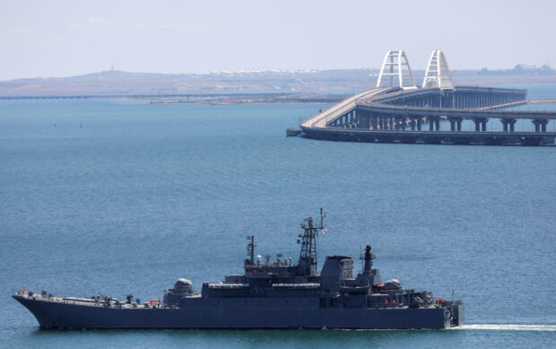 A Russian Navy amphibious landing ship that was deployed to transport cars across the Kerch Strait, moves near the Crimean Bridge, a section of which was damaged by an alleged overnight attack, as seen from the city of Kerch, Crimea, July 17, 2023. REUTERS/Alexey Pavlishak/File Photo