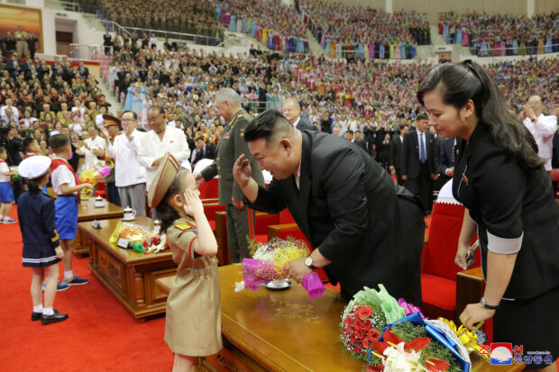 North Korean leader Kim Jong Un greets children as he attends a performance, in this image released by North Korea's Korean Central News Agency on July 27, 2023.  KCNA via REUTERS