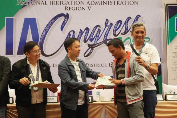 Ako Bicol Party-list Rep. Elizaldy Co (center) gives a certificate to a Badjao fisherman for the grant of a motorized boat and other essential fishing equipment during the National Irrigation Administration AI Congress in Legazpi City, Albay, on Friday, June 30, 2023. Albay 2nd District Rep. Joey Salceda (right) is also present during the event. Photo from the Office of Rep. Co (Photo courtesy of Ako Bicol Party-list)