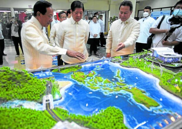 FLAGSHIP PROJECTS President Marcos looks at a diorama of major infrastructure projects during his visit to the Department of Public Works and Highways (DPWH) Central Office on June 23 for its 125th anniversary. With the President are DPWH Secretary Manuel Bonoan and Senior Undersecretary Emil Sadain. —PPA POOL  