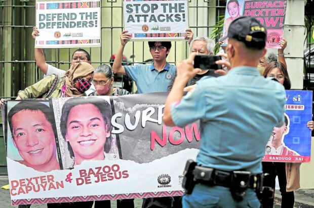 FOR HIS FILE A policeman makes no secret of his task to take photos of the people who joined Friday’s demonstration for the missing activists Dexter Capuyan and Bazoo de Jesus outside the Court of Appeals in Manila. —RICHARD A. REYES