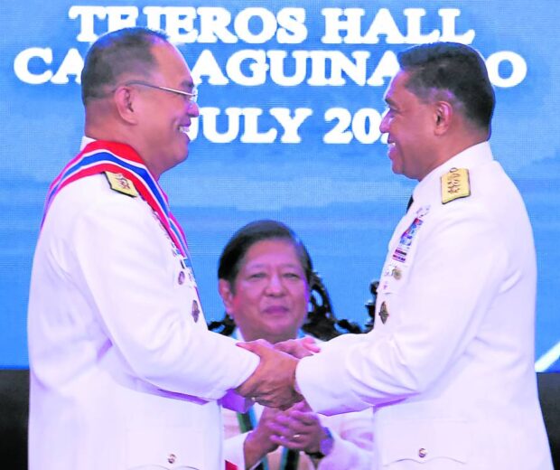 ‘SUPERVISION’ President Marcos on Friday witnesses the change of command over the Armed Forces of the Philippines between the new chief of staff, Lt. Gen. Romeo Brawner Jr. (left), and now retired general Andres Centino, whose next assignment is presidential adviser on the West Philippine Sea. —NIÑO JESUS ORBETA      
