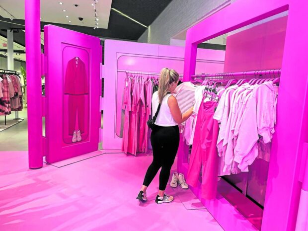 FANTASY WORLD A shopper browses Barbie-themed merchandise during the Barbie pop-up event in Zara's Soho store in New York City on July 20. The release of the new Barbie film has ignited a world-wide demand for products and services that reflect the doll and her pink-encrusted universe. REUTERS