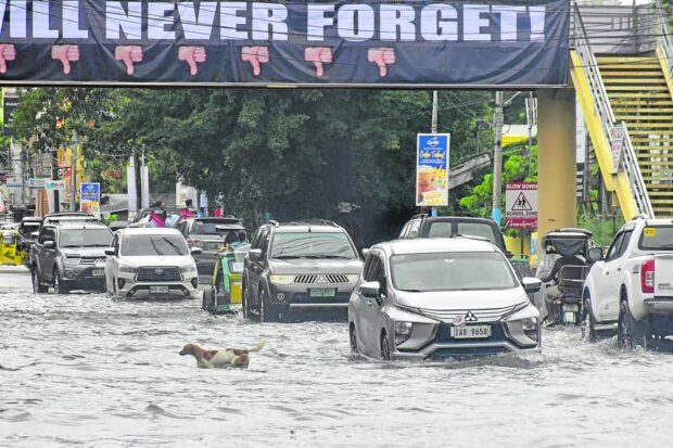 HIGH TIDE DRIVE Supertyphoon “Egay” (international name: Doksuri) has left the country but the heavy rains it dumped in northern Luzon from Tuesday to Thursday continue to flood a number of areas, such as Tapuac road in Dagupan City, on Friday. —WILLILE LOMIBAO