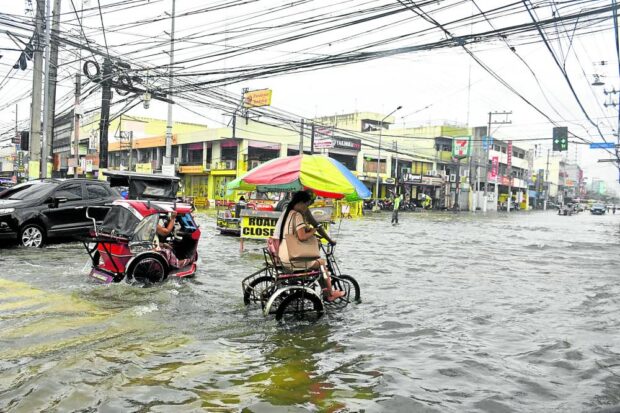 Vehicles cruise along flooded roads in Dagupan City due to high tide.and rain brought by typhoon Egay All 31 barangays of the city are under water.