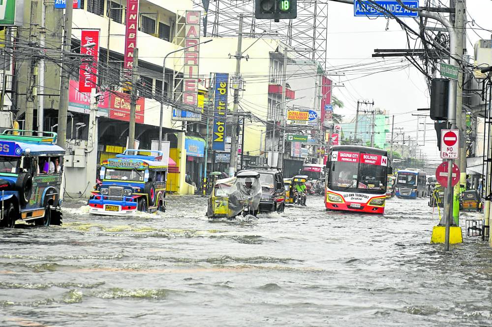 DAGUPAN NAVIGATION A combination of high tide and heavy rains brought about by Typhoon “Egay” resulted in this situation in one of Dagupan City’s commercial areas on Saturday. A total of 31 barangays in the city were flooded and at least 245 families were forced to evacuate, officials said. —WILLIE LOMIBAO