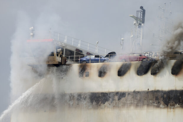 A cargo ship docked at the East Coast's biggest port smoldered for a third day and will likely burn for several more