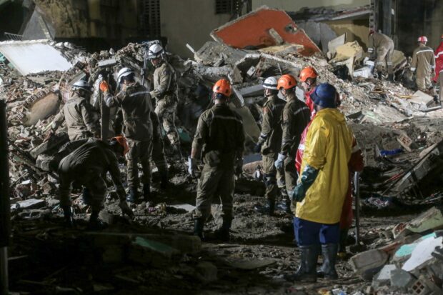 Rescue teams search for victims in the rubble of a collapsed building in the municipality of Paulista, on the outskirts of Recife, in Brazil's northeastern state of Pernambuco, on July 7, 2023. At least 11 people died and another three --a woman and two children-- remain missing after the collapse on Friday of an illegally occupied building, authorities said Saturday. (Photo by Alexandre AROEIRA / AFP)