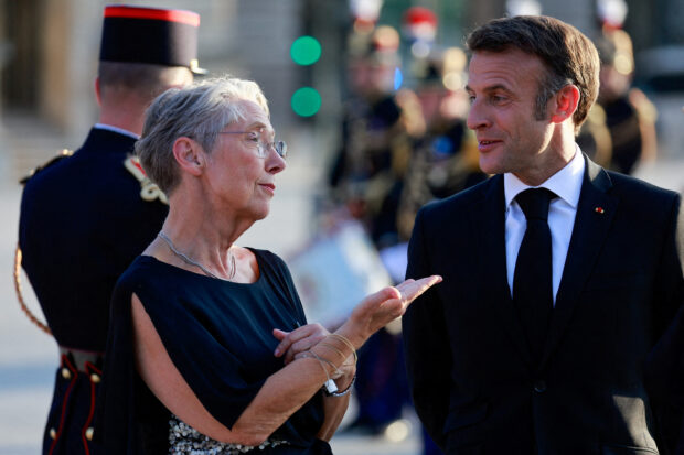 FILE PHOTO: Borne and Macron arrive at a dinner held at the Louvre in Paris