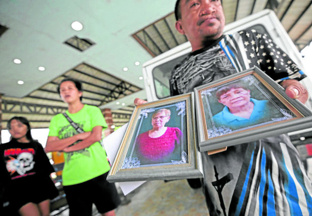 PRINCESS AYA / JULY 28, 2023A funeral worker prepares the portraits of the victims to be send to Talim Island from Binangonan Port in Rizal province. At least 26 passengers were killed after the passenger boat capsized due to strong winds and heavy rain brought Typhoon Egay. INQUIRER PHOTO / RICHARD A. REYES
