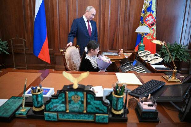 Russian President Vladimir Putin meets with Raisat Akipova, an 8-year-old girl from Dagestan, at the Kremlin in Moscow
