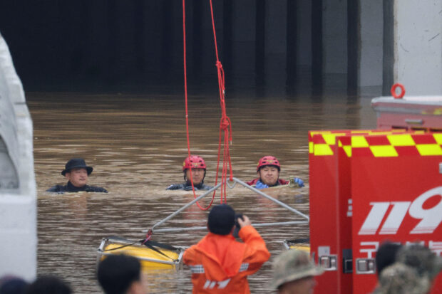 Rescue workers take part in a search and rescue operation at an underpass that has been submerged by an flooded river caused by torrential rain in Cheongju