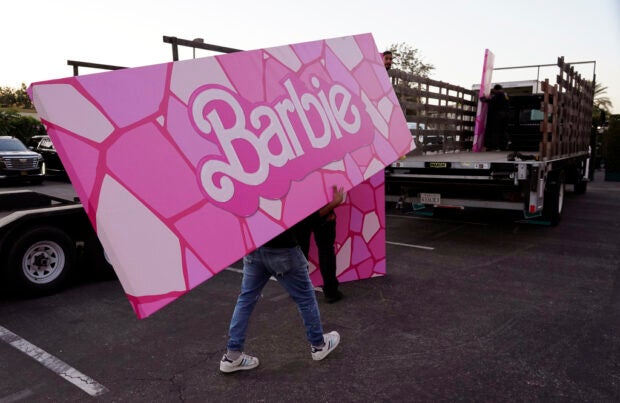 A crew member carries away a piece of “Barbie” set design after the premiere of the film, Sunday, July 9, 2023, at the Shrine Auditorium in Los Angeles. (AP Photo/Chris Pizzello)