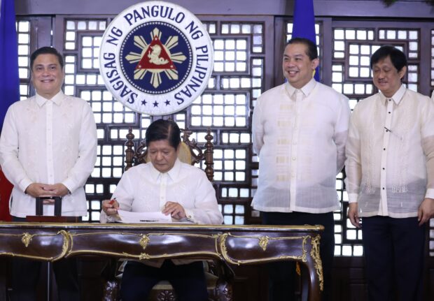 President Ferdinand R. Marcos Jr. signs the New Agrarian Emancipation Act at Malacanang Palace, absolving 610,054 farmers of P57.56 billion in debt. In attendance are Speaker Romualdez, Senate President Zubiri, and Agrarian Reform Secretary Estrella III.
