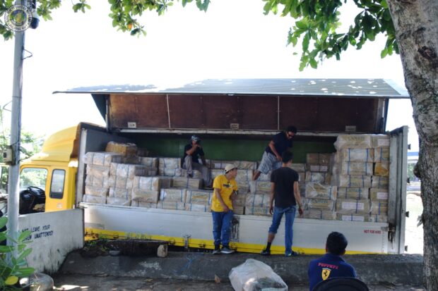 Navy and Customs personnel intercept a motorized boat from Sulu loaded with over P13.8 million worth of smuggled cigarettes off Samal island on Sunday, authorities say. (Photos courtesy of Naval Forces Eastern Mindanao) 