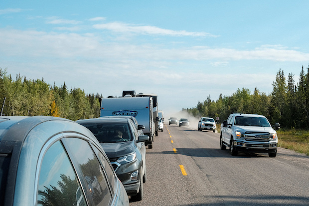 Cars pass a line of vehicles waiting for fuel, after an evacuation order was declared due to the proximity of a wildfire in Yellowknife, in Fort Providence, Northwest Territories, Canada August 17, 2023.  