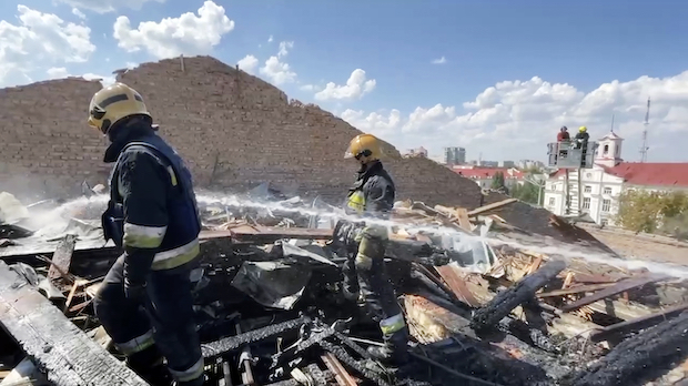 In this photo taken from video provided by the Ukrainian Emergency Service, firefighters work on the roof of the Taras Shevchenko Chernihiv Regional Academic Music and Drama Theatre damaged by Russian attack in Chernihiv, Ukraine, Saturday, Aug. 19, 2023.
