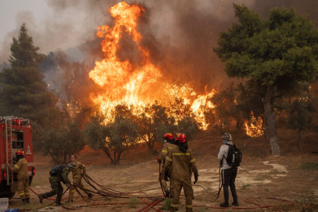 Firefighters and volunteers try to tackle a wildfire burning in the village of Hasia, near Athens, Greece August 22, 2023. REUTERS/Alkis Konstantinidis