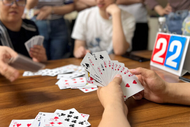 Finance professionals learn how to play guandan, a poker-like card game, during a training session in Beijing, China August 6, 2023. REUTERS/Yew Lun Tian/File photo