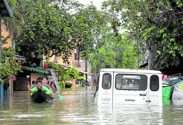 VILLAGE RIDE Floodwaters rise to at least 1.52 meters (5 feet) in the inner roads of Barangay Frances in Calumpit town, Bulacan province, on Monday, forcing residents to take a boat. Heavy rains in the past few days also flooded sections of the North Luzon Expressway in Bulacan and Pampanga on Monday and Tuesday. —LYN RILLON