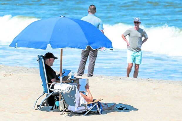 ‘GORGEOUS BEACH DAY’ Secret Service agents accompany US President Joe Biden at the shores of Rehoboth, Delaware. —AFP   