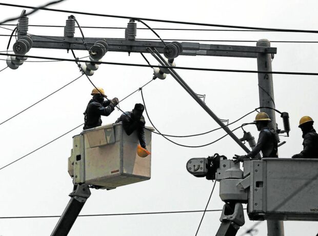 PHOTO: Meralco linemen working on an electric pole STORY: Higher electricity prices forecast until May