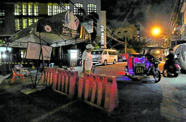 A volunteer of Barangay Pitogo, which formerly belonged to Makati City, standsguard at a makeshift barricade made of plastic road dividers across a street leading to Pitogo High School (PHS)