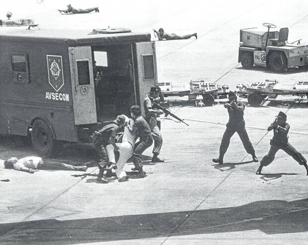 Ninoy Aquino’s body is hoisted by airport security personnel who had escorted him upon his arrival in Manila on Aug. 21, 1983. They would later be charged with his murder