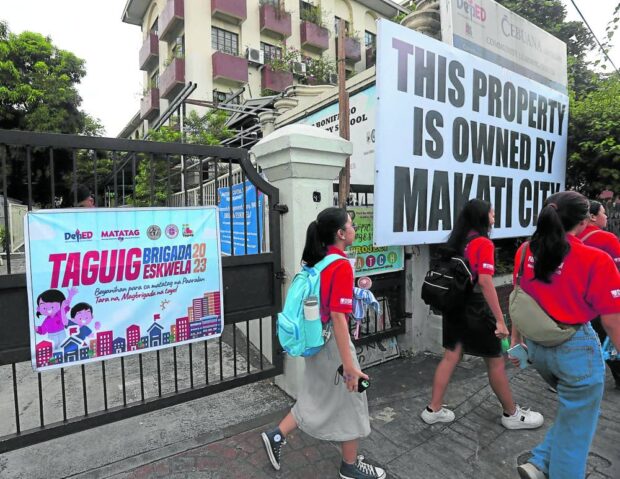 Students pass by Fort Bonifacio Elementary School, which Makati City claims it owns.