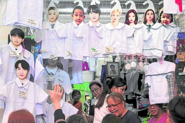 Parents and their children crowd the ready-to-wear section of the public market in Marikina City on Monday, Aug. 28, 2023, to buy school uniforms as classes in public schools around the country resume today. 