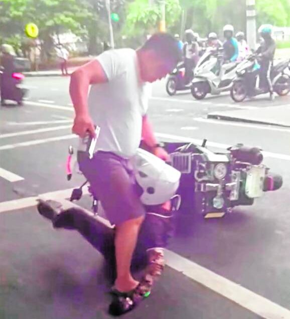 Police Staff Sgt. Marsan Dolipas is caught on video pinning to the ground a motorcycle rider identified as Angelito Rencio after the latter allegedly sideswiped his car in Makati City on Aug. 25, 2024. 