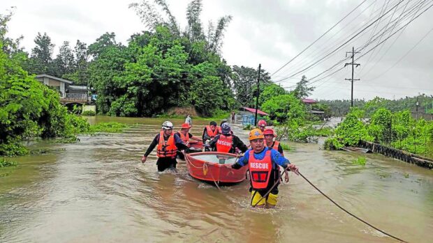 TRAPPED Emergency responders on Wednesday wade through floodwaters to assist trapped residents at Barangay Quiling Norte in Batac City after Typhoon “Goring” (international name:Saola) battered Ilocos Norte province. —PHOTO COURTESY OF BATAC CITY GOVERNMENT
