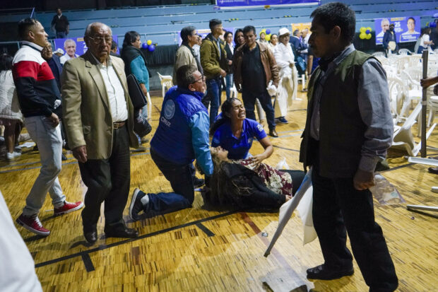 A supporter of presidential candidate Fernando Villavicencio lies wounded after Villavicencio was shot to death while at a campaign rally outside a school in Quito, Ecuador, Wednesday, Aug. 9, 2023. (API via AP)